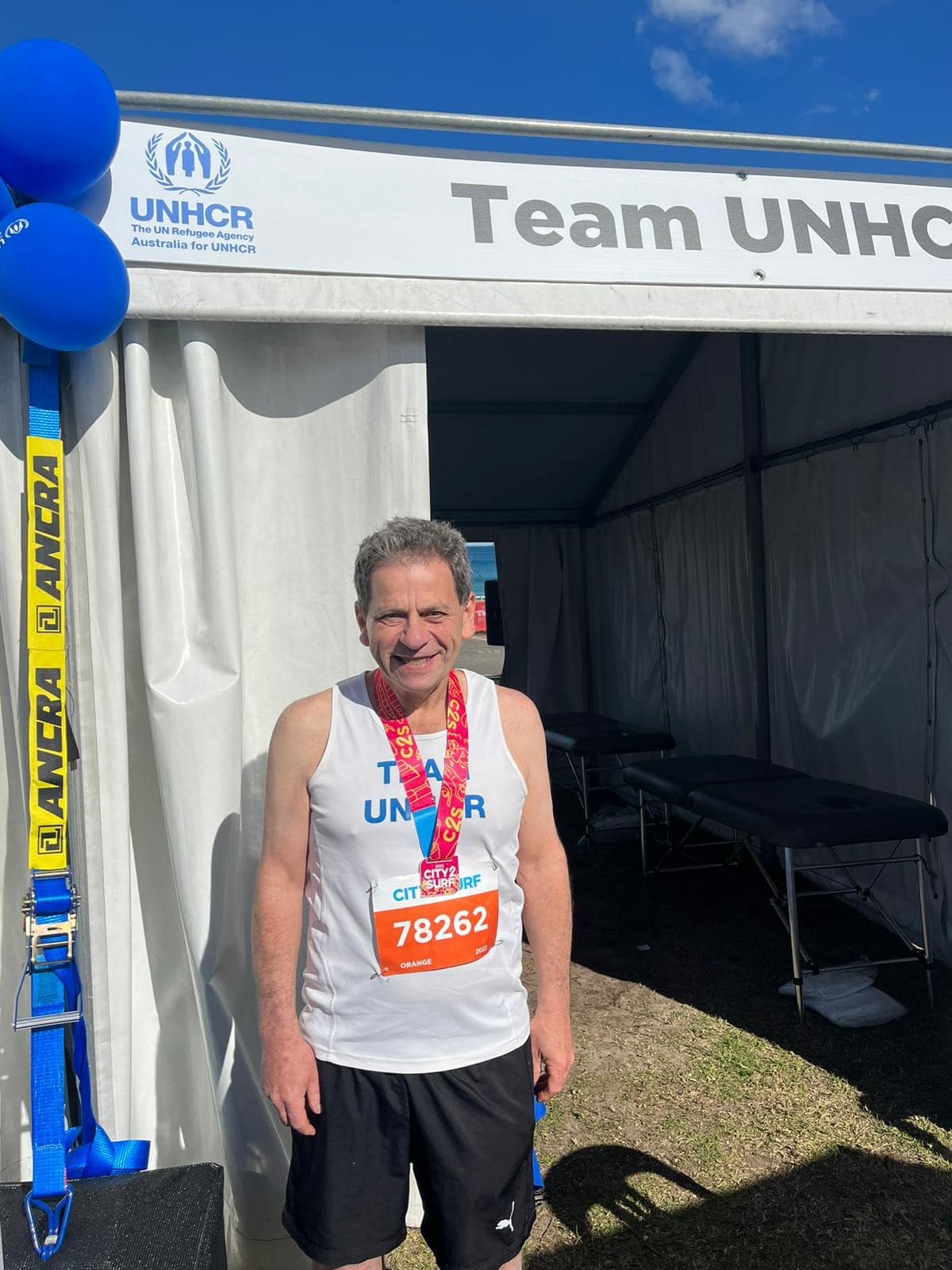 Community fundraiser, Bernie smiles at camera after completing the City to Surf in Sydney.