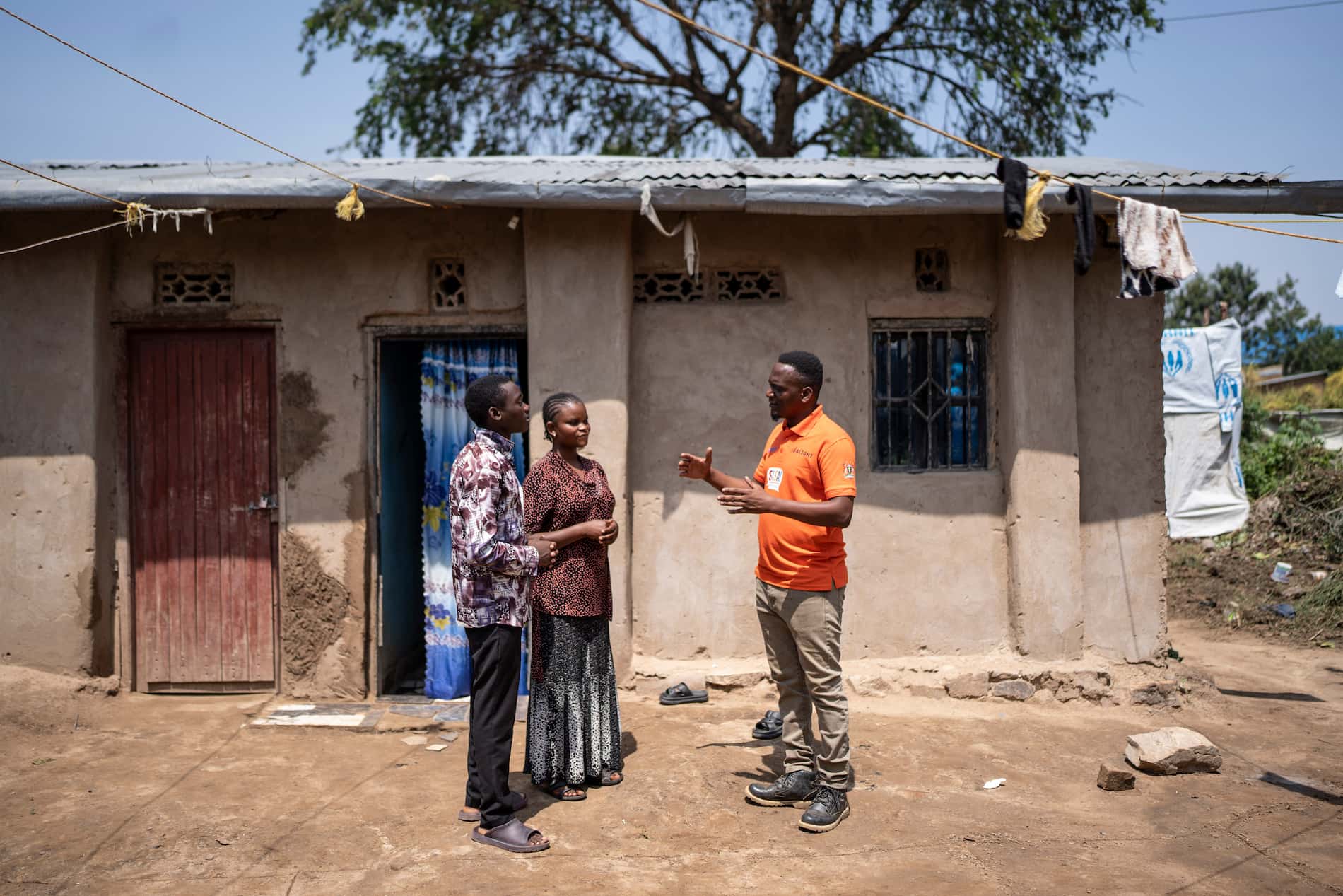 A caseworker with ALIGHT (UNHCR's main protection partner in Nakivale refugee settlement), speaks with Congolese refugee Dominique* and her brother.