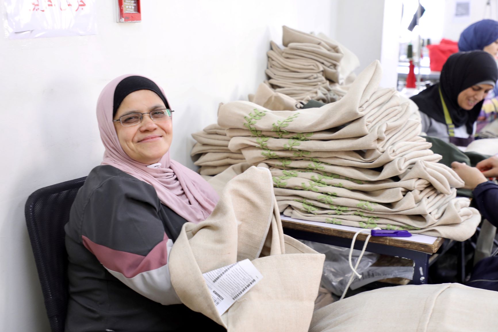 Refugee and Jordanian women sew cushion covers at a JRF run workshop in downtown Amman which will be sold at IKEA