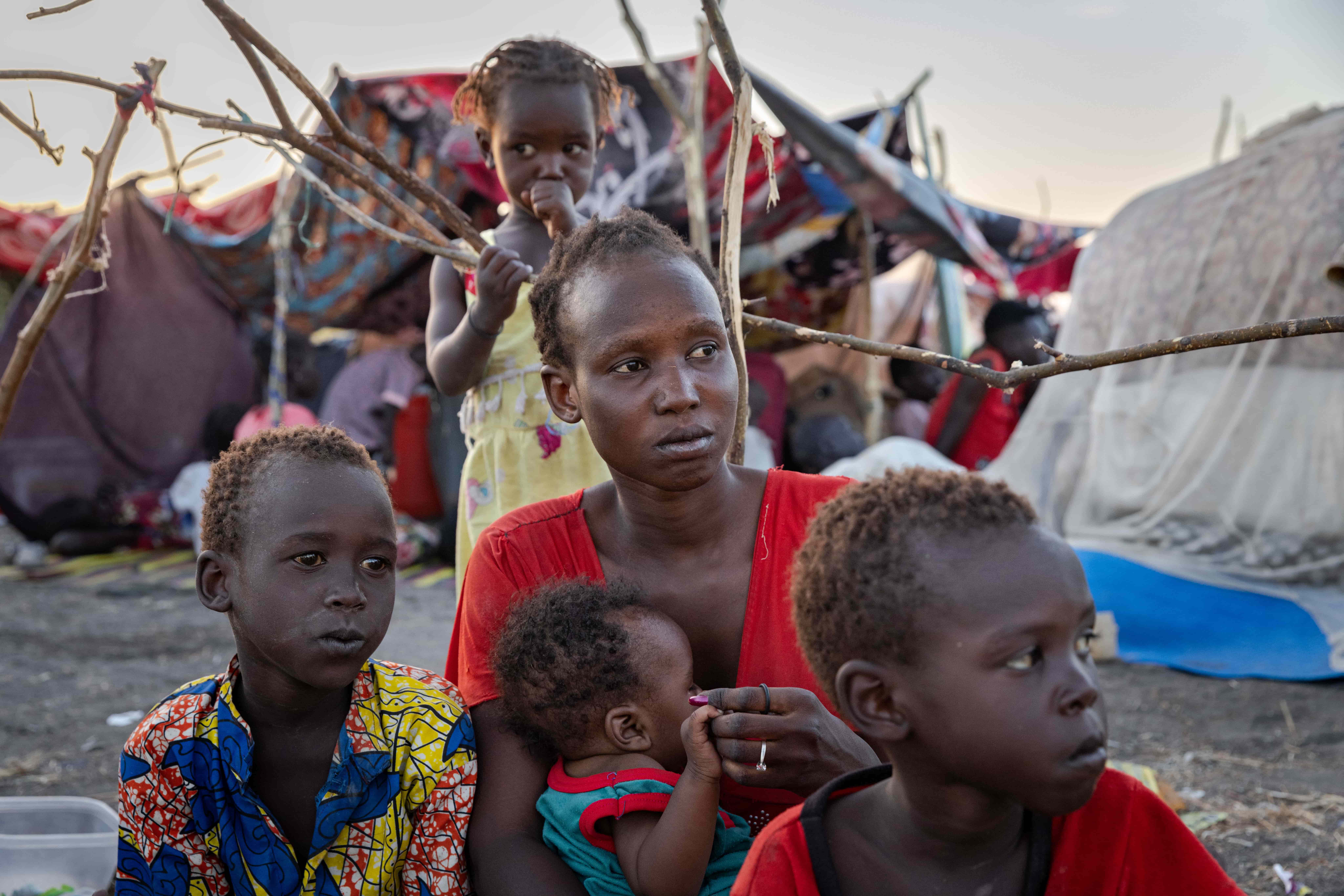 Eliza sits with her children at the UNHCR transit centre in Renk, South Sudan