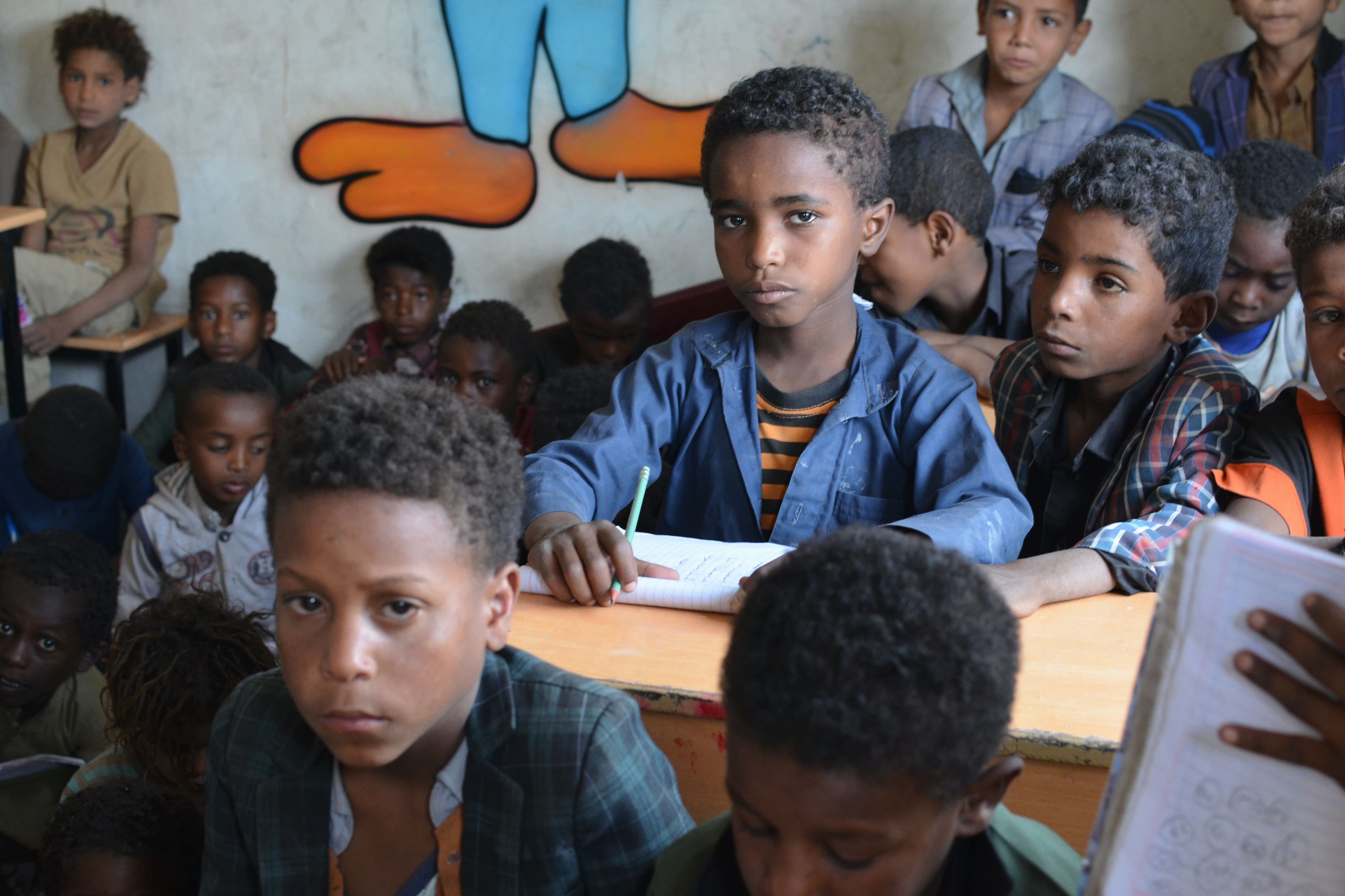 Boy sitting in a classroom at a UNHCR-rehabilitated school in Yemen.