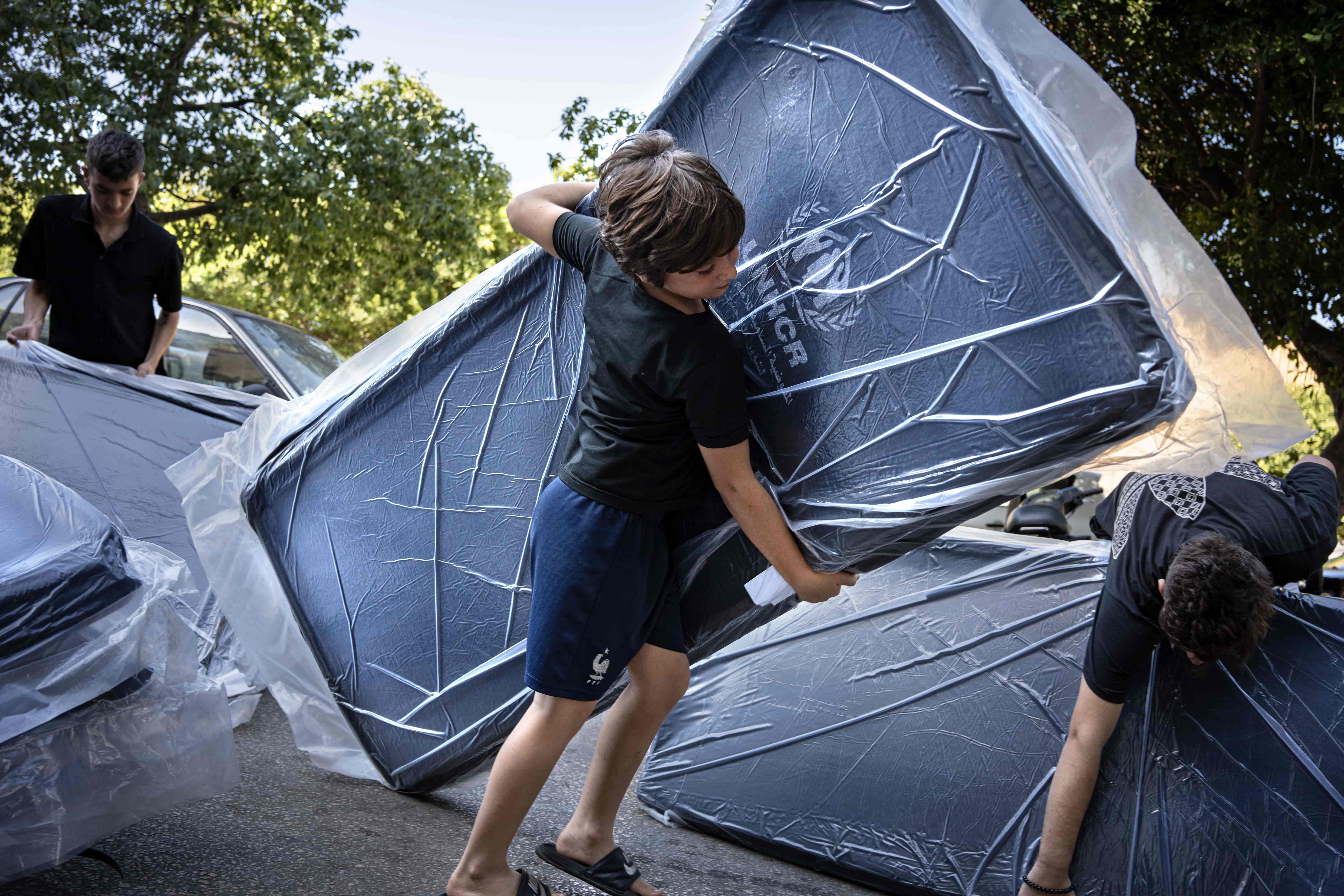 Displaced children carry UNHCR mattresses outside a hospital in Beirut Lebanon