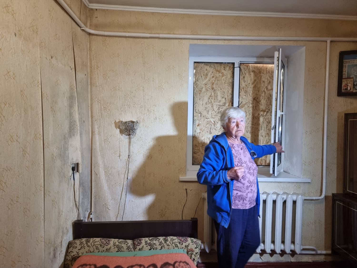 Valentyna shows the repairs made to her windows. UNHCR is helping vulnerable Ukrainian families repair their homes before winter.