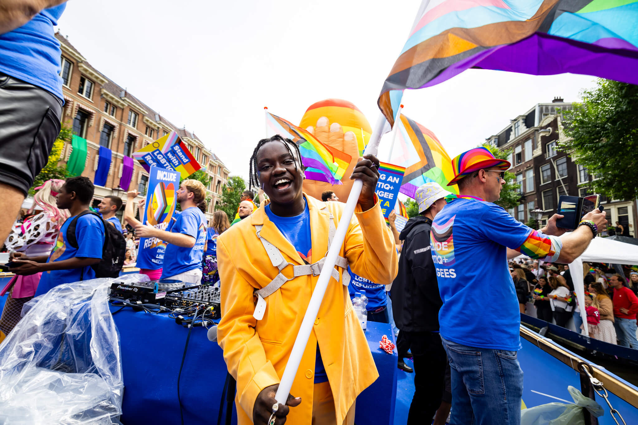 LGBTIQ+ refugees wave pride flags and hold up signs during a pride march in Amsterdam, The Netherlands