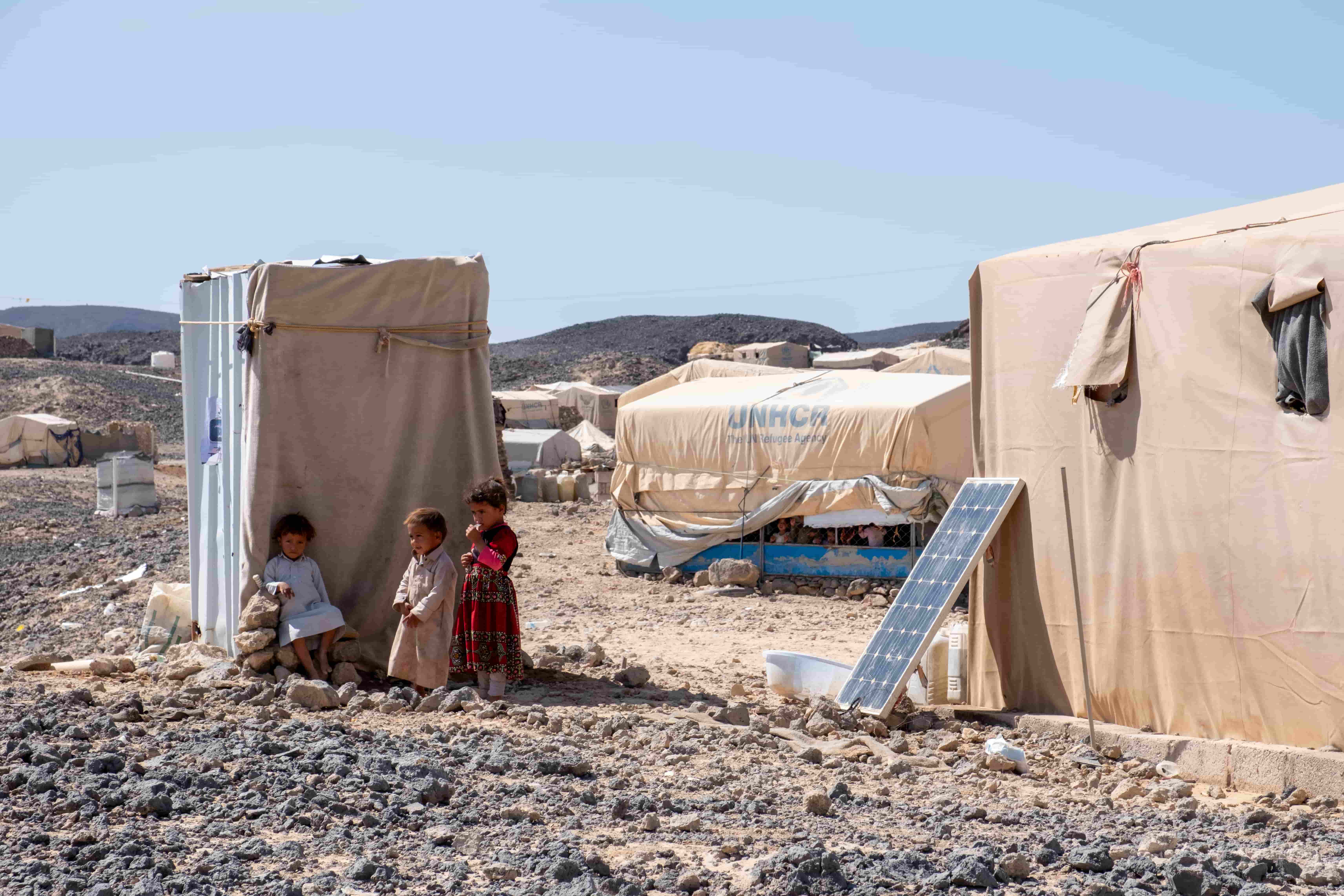 Yemeni children Radad, Arif, and Nazih seek shade at a site for internally displaced people.
