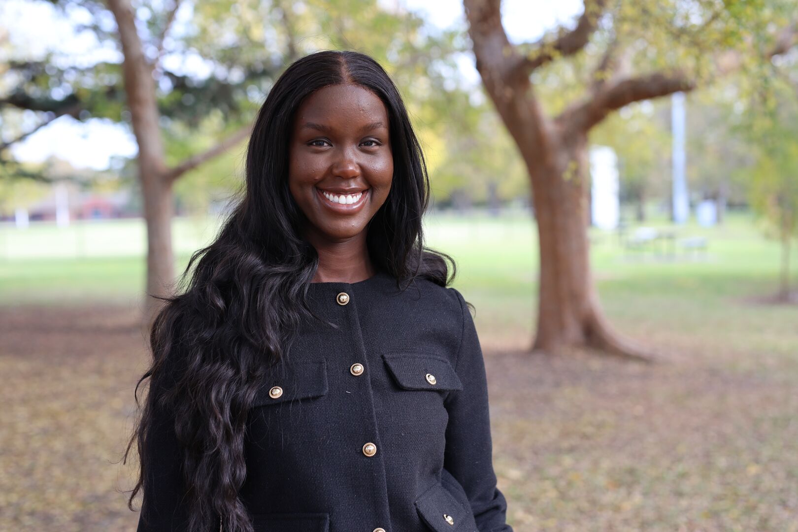 Paraman Tot is photographed standing in a park, wearing a navy jacket