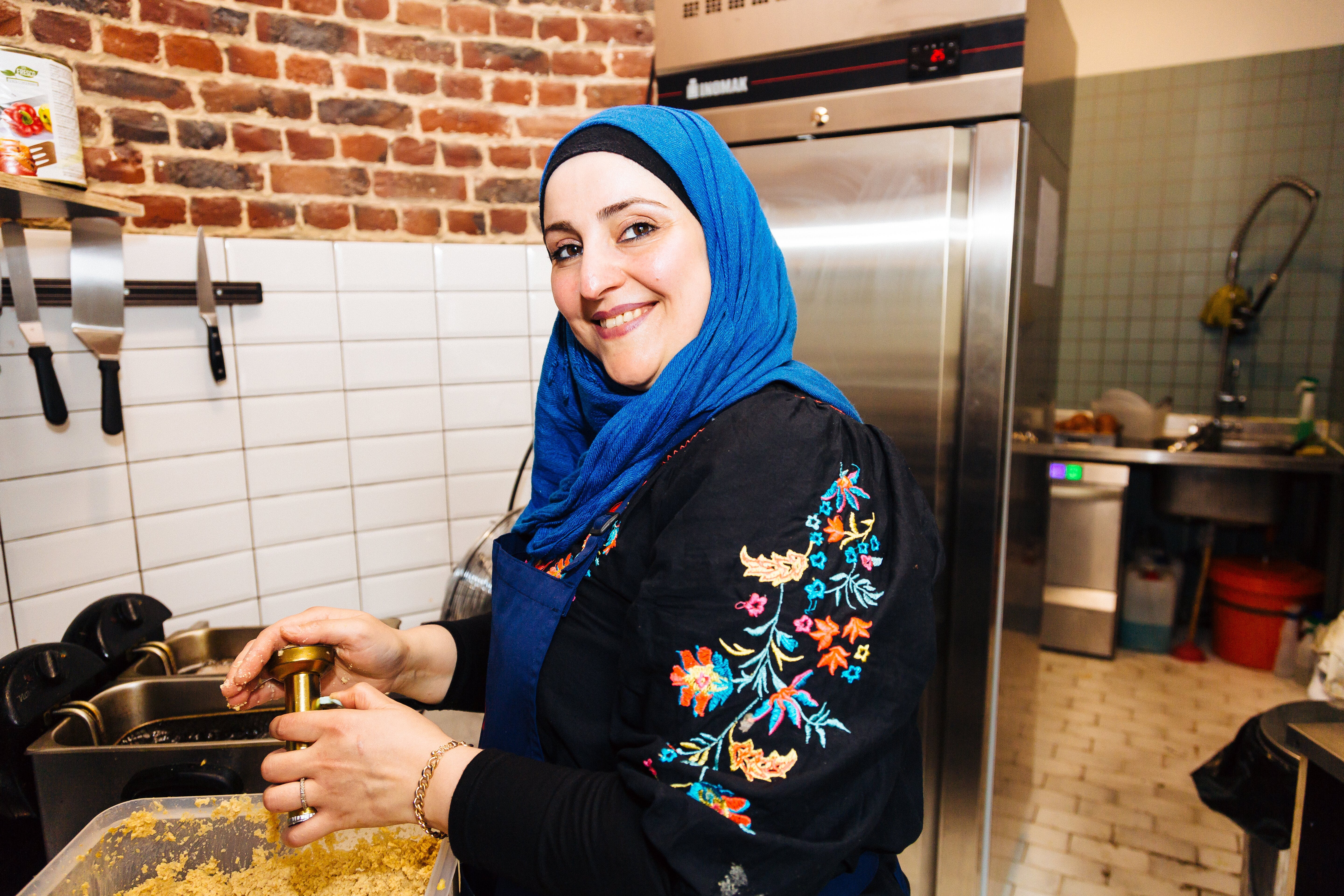 Syrian refugee woman Shahla cooks traditional food in a kitchen in Belgium.