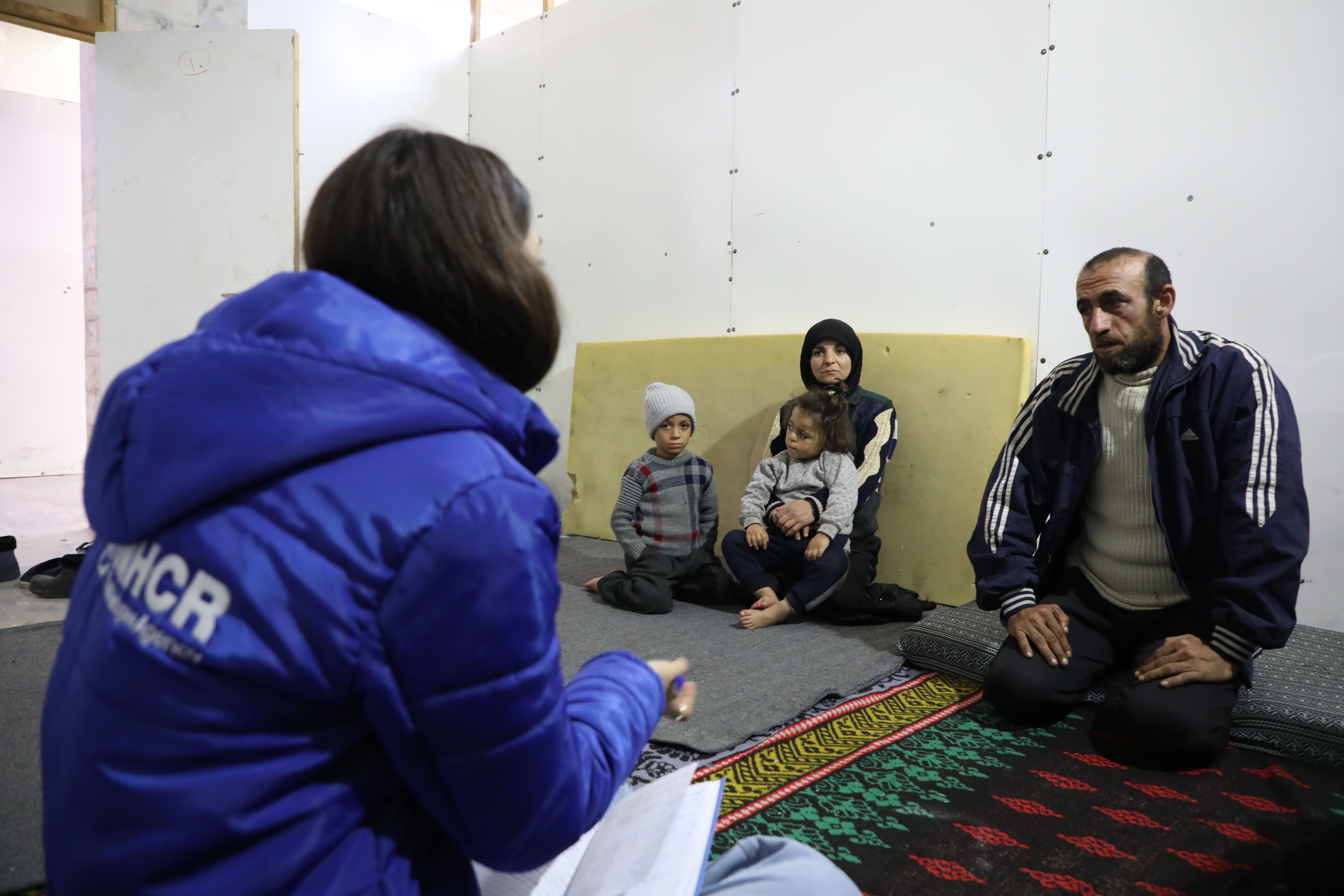 A UNHCR team meets Abdulla Ghalia, a father-of-four who fled the violence that erupted in Aleppo on 27 November 2024, at the Sports City collective shelter in Latakia, Syria. 