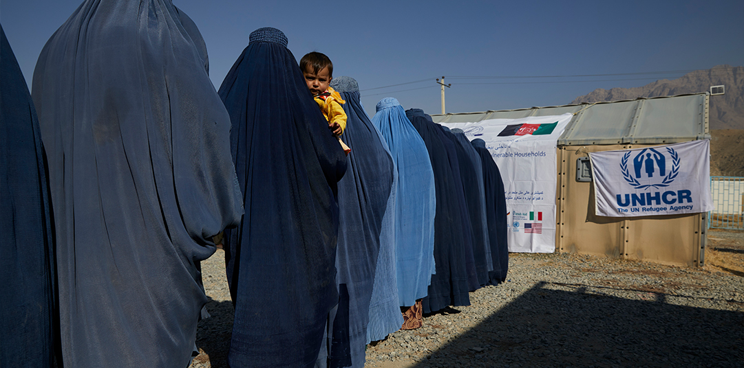 Displaced families queue for cash assistance © UNHCR/Andrew McConnell