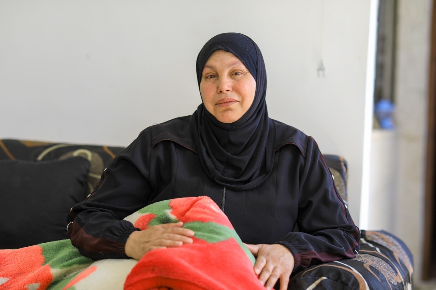 Khloud, Syrian refugee in Jordan holds blanket