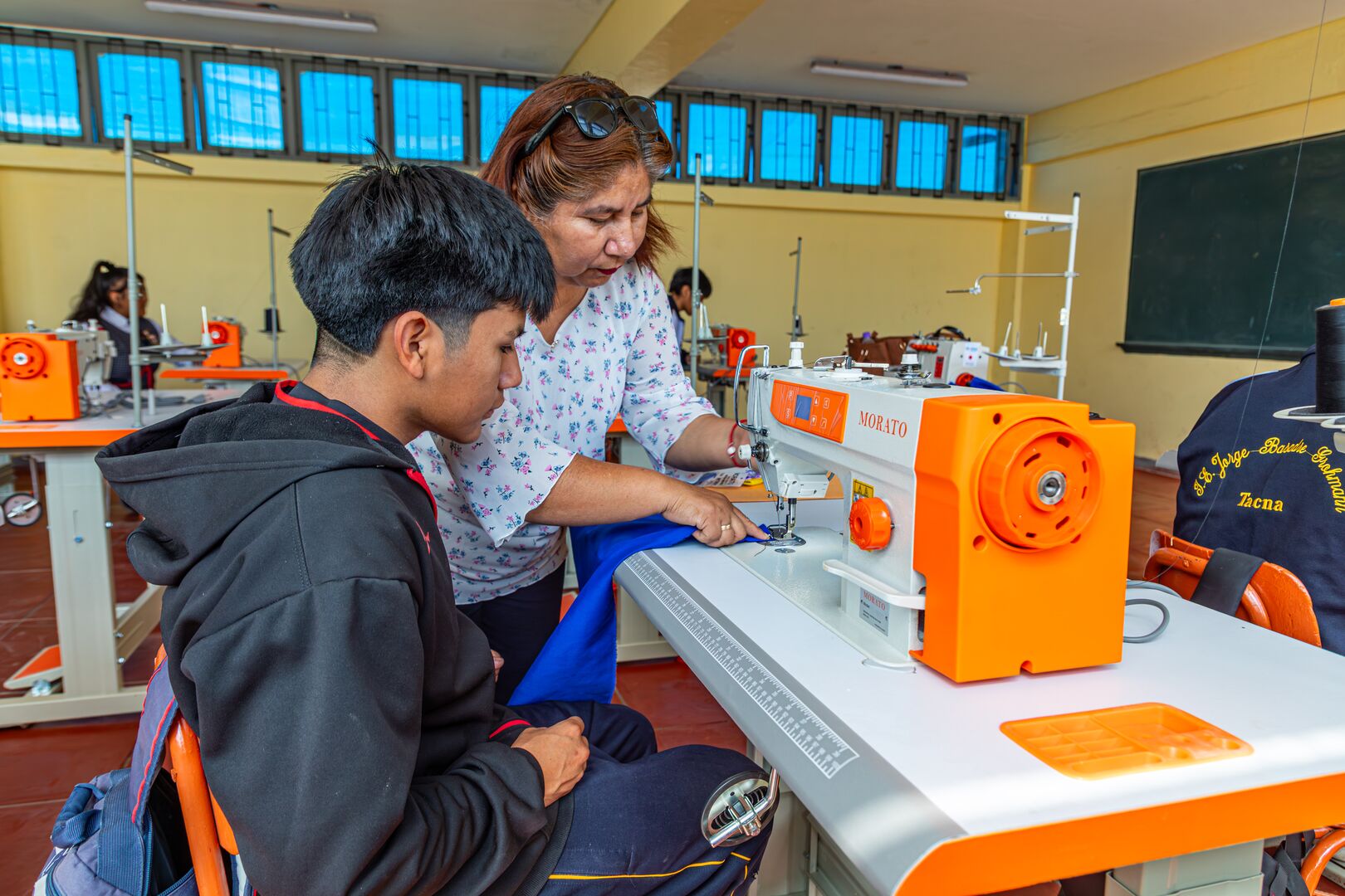 Refugee and local teenagers learn to sew using machines donated by UNHCR in Tacna, Peru.