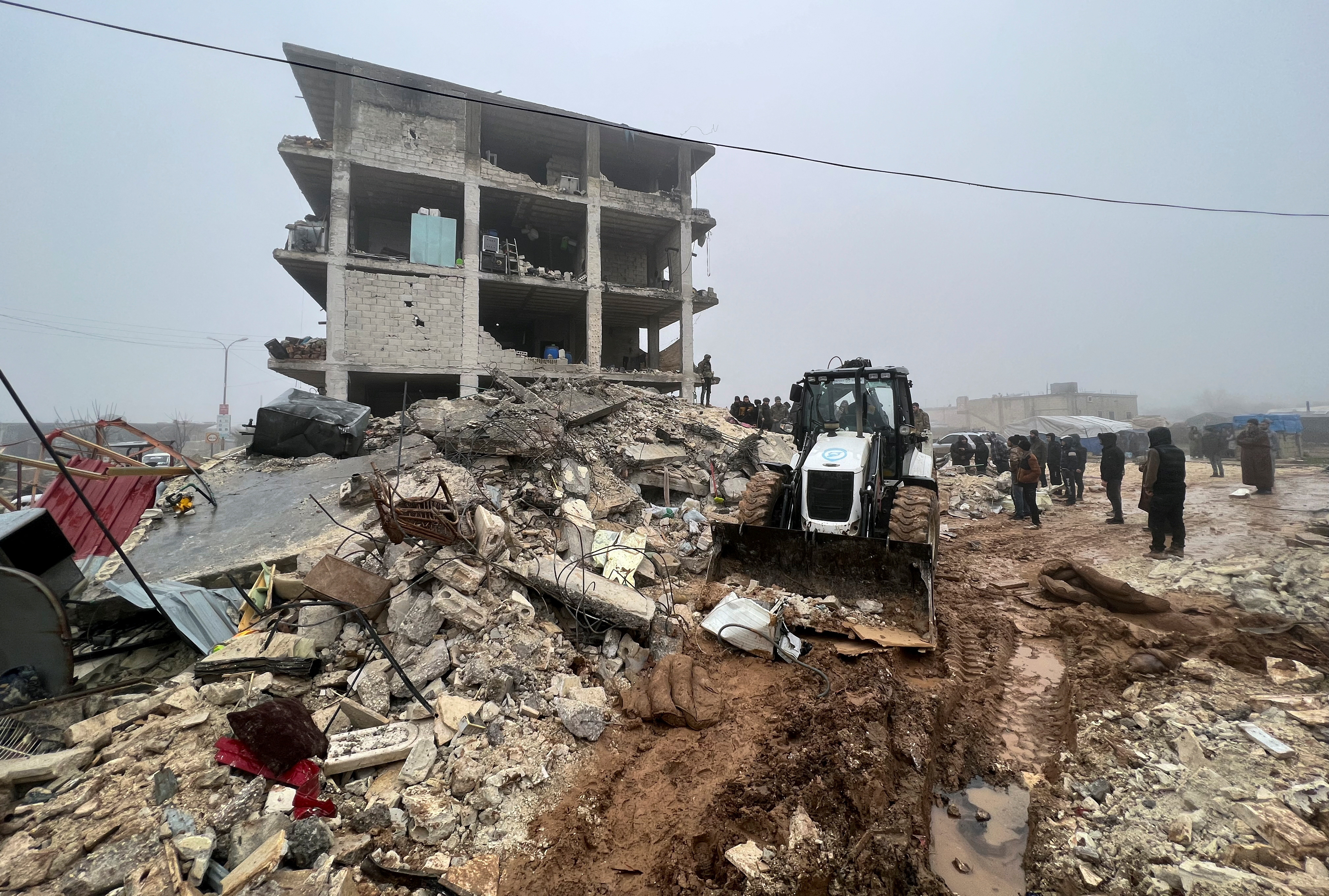 Rescuers search for survivors under the rubble, following an earthquake, in rebel-held town of Jandaris, Syria
